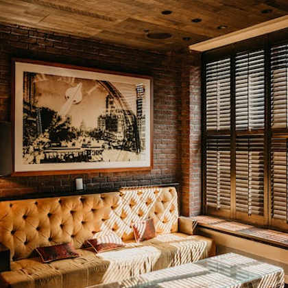 a room with a tufted sofa and a framed picture on the wall.