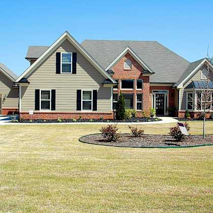 a house with a grey roof and a brown brick chimney.