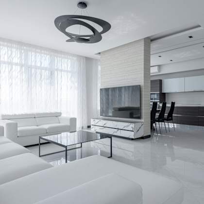 a modern living room with white furniture and a large window.