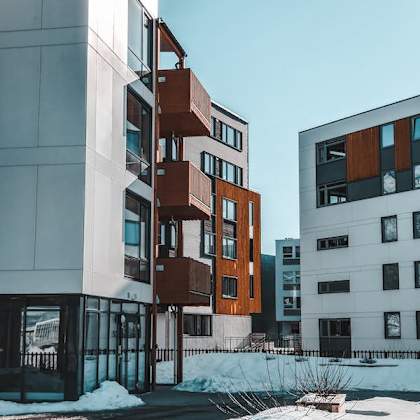 a modern building with a white facade and a brown balcony.