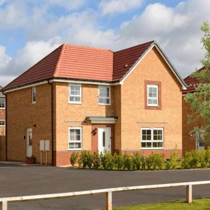 a red brick house with a white fence in front.