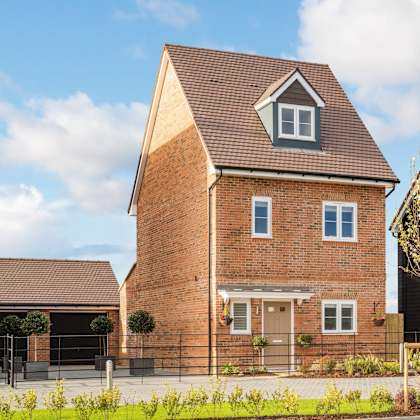 a red brick house with a pitched roof and a small window on the front.