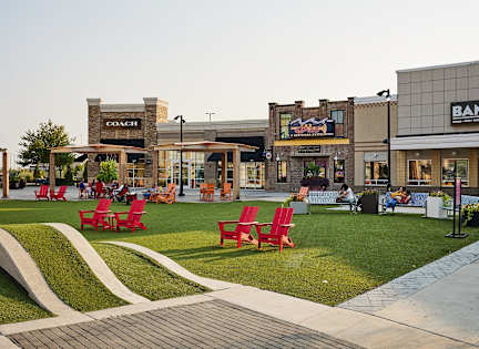 a lawn with red chairs outside of a bam store