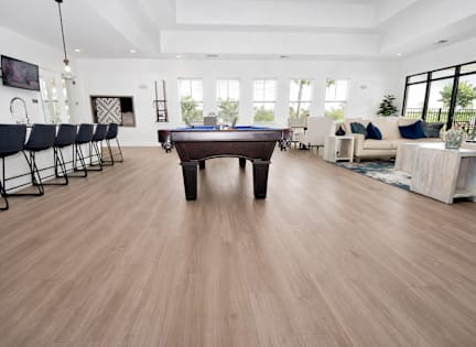 A pool table is in the middle of a room with a wood floor. at GRANDVIEW AT CLEAR POND Apartments , MYRTLE BEACH, SC, 29579
