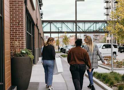 Two people walking down a sidewalk.