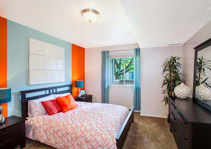 A bedroom with a bed, nightstands, and a window.