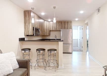 a kitchen with a bar with three stools in front of it
