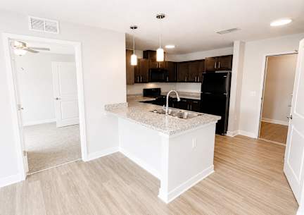 A blue and white townhouse with a front yard and a driveway.at Hawthorne Pointe, Bondurant, IA
