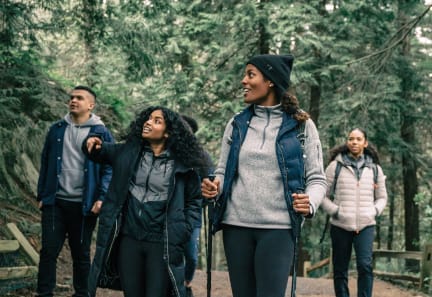 a group of people walking on a trail in the woods