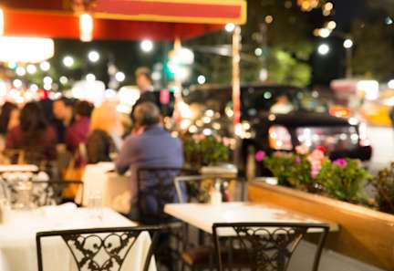 A restaurant with people dining outside at night.