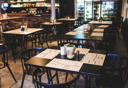 A restaurant with tables and chairs and a menu on the table.