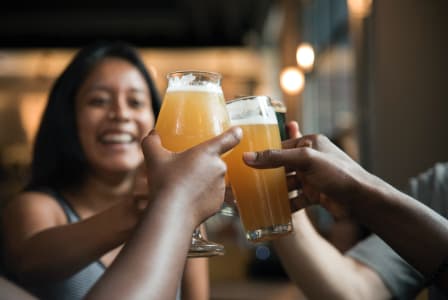 a group of people holding up glasses of beer