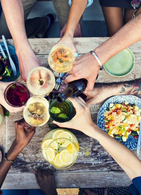 a group of people sitting around a table drinking wine