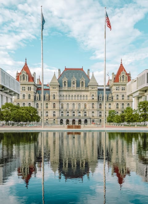 a large building with two flags in front of it