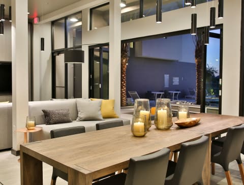 a dining area with a wooden table and a living room with a couch