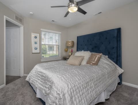 a bedroom with a large bed and a ceiling fan