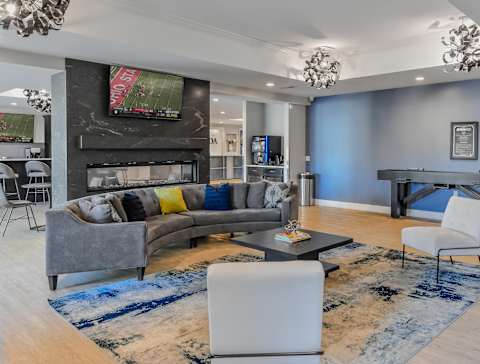 a clubhouse with blue walls and a gray couch and a table and chairs