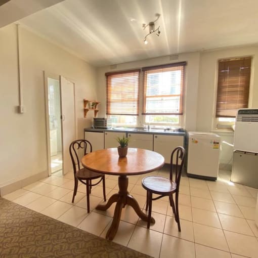 a kitchen with a table and a refrigerator and a sink