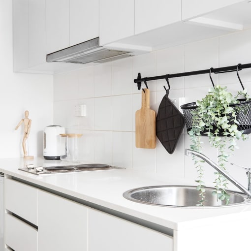 a white kitchen with a sink and white cabinets