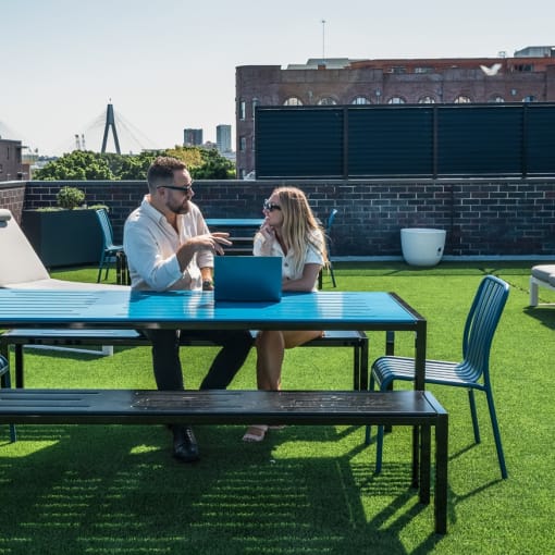 a man and a woman sitting at a table with a laptop