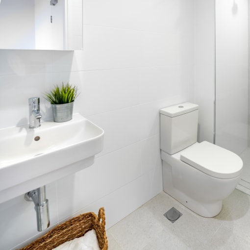 a white bathroom with a toilet and a sink