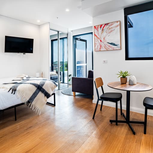 a bedroom with a bed and a table with chairs and a tv