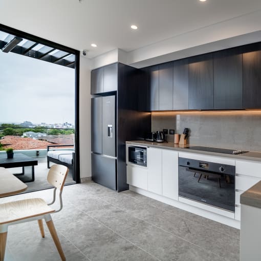 a kitchen with black and white cabinets and a large window