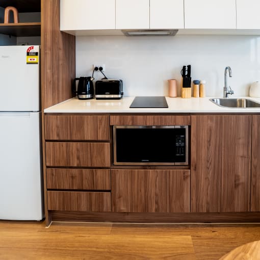 a kitchen with a sink and a refrigerator in a hotel room