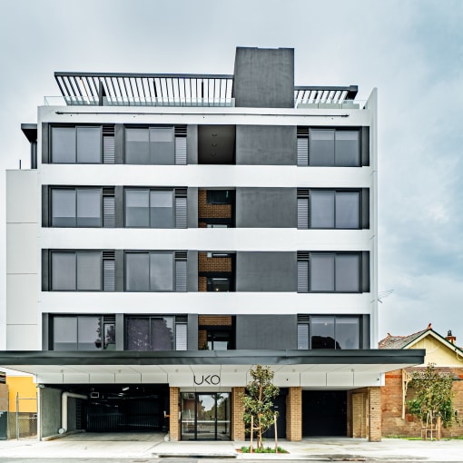 the condo building has a facade of black and white asymmetrical glass windows and a