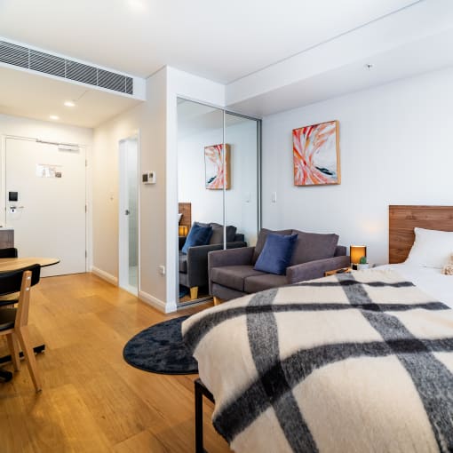 a bedroom with a bed and a couch in a hotel room