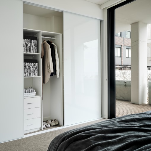 a bedroom with a closet and a bed and a sliding glass door