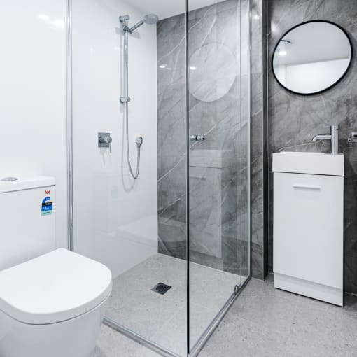 a white bathroom with a shower and a toilet