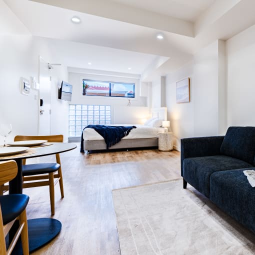 a living room with a couch and a table and a bed