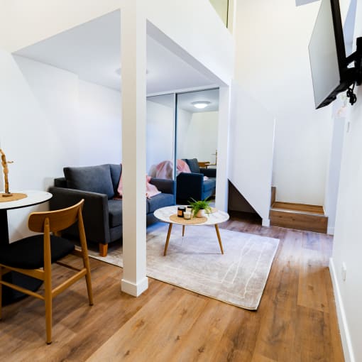 a living room with a small table and a couch and a mirror