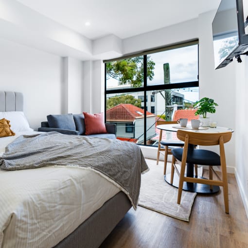 a bedroom with a bed and a large window