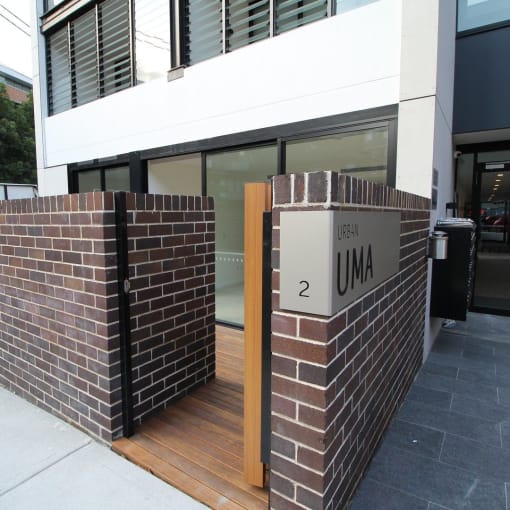 the entrance to a building with a brick wall and a sign that reads 2 um