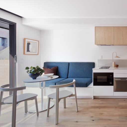 a small living room with a small kitchen and a table and chairs