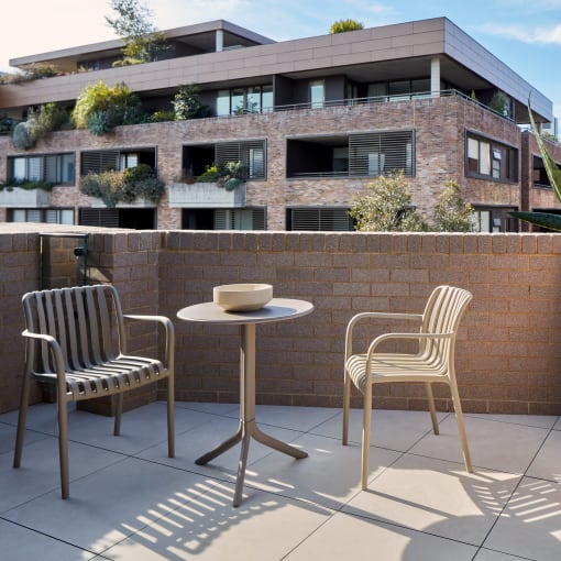 a balcony with a table and chairs and a brick wall