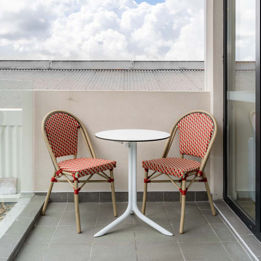 a patio with two chairs and a table on a balcony