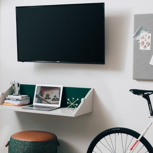 a wall with a tv and a desk with a bike