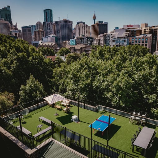 a yard with a tennis court and a city in the background