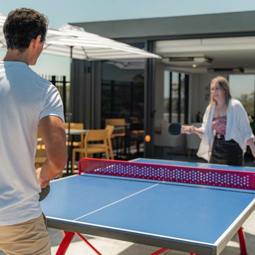 a man and a woman playing ping pong on a table