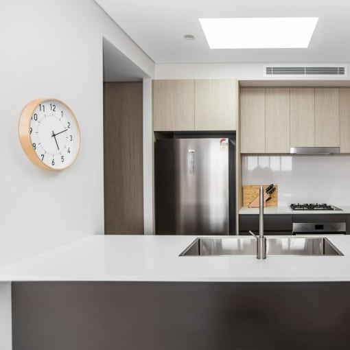 a kitchen with a sink and a clock on the wall