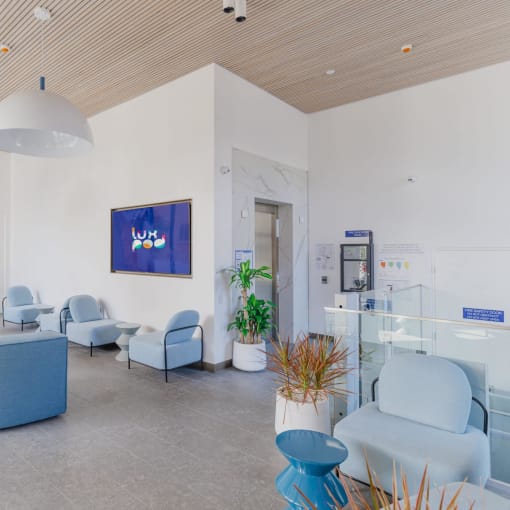 the waiting room of a hospital with blue couches and chairs
