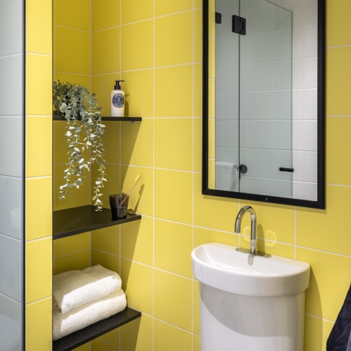 a yellow bathroom with a sink and a mirror