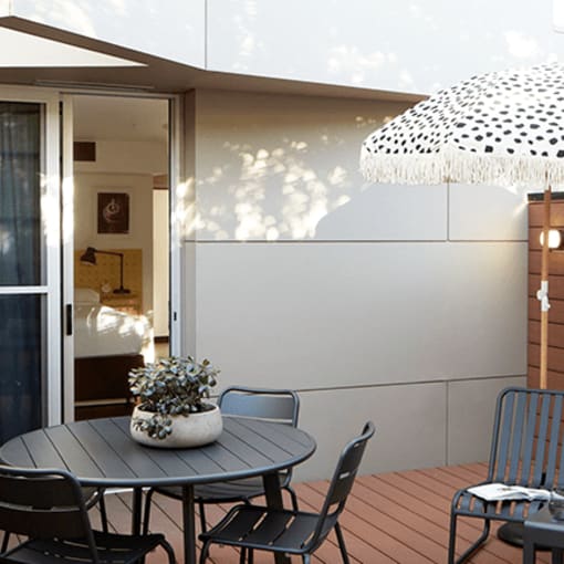 a small patio with a table and chairs and an umbrella