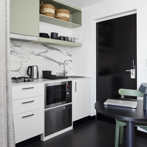 a small kitchen with a table and a black door