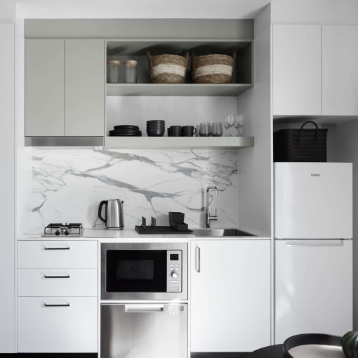 a black and white kitchen with white cabinets and a microwave