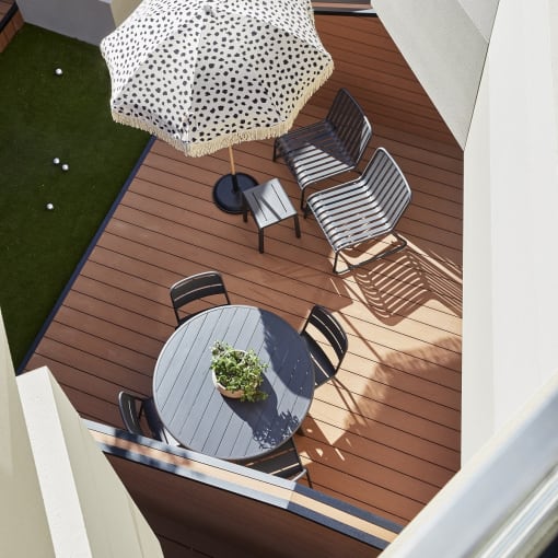 a deck with a table and chairs and an umbrella