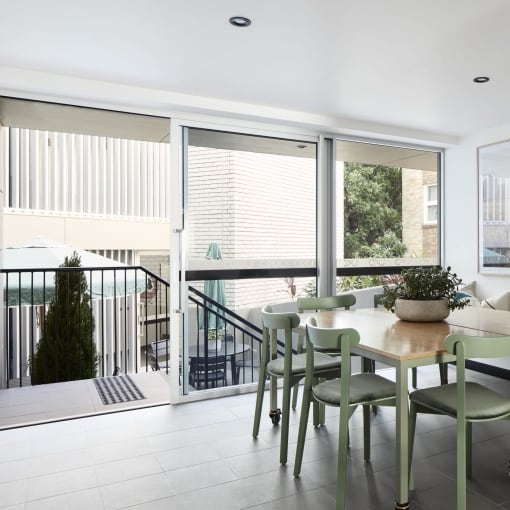 a dining room with a table and chairs and a balcony